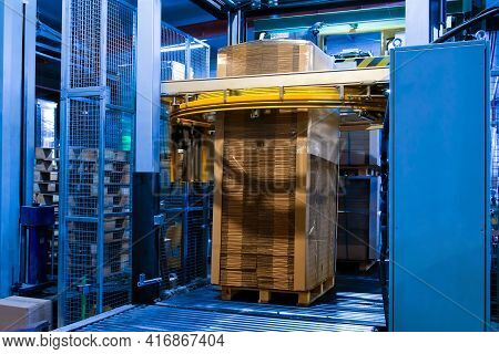 Industrial Equipment - Typical Stretch Wrapping Machine In Process Of Work. Packaging Of Corrugated 