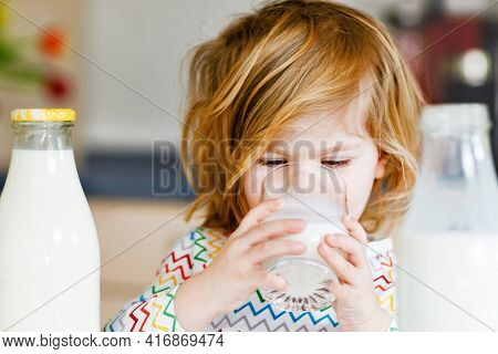 Adorable Toddler Girl Drinking Cow Milk For Breakfast. Cute Baby Daughter With Lots Of Bottles. Heal