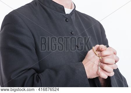 Catholic priest's hands holding the rosary