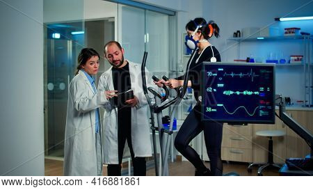 Scientist Analysing Ekg Results Looking At Monitor Examining Heart Rate Of Athlete