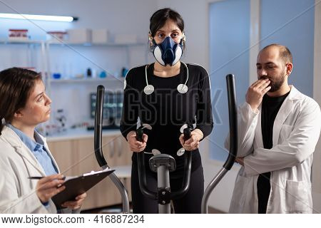 Woman Athlete With Mask Doing Fitness Exercises In Science Sport Lab