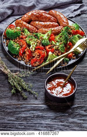 Italian Cotechino Pork Sausages Braised With Brown Lentils, Red Pepper, And Broccoli Served On A Bla