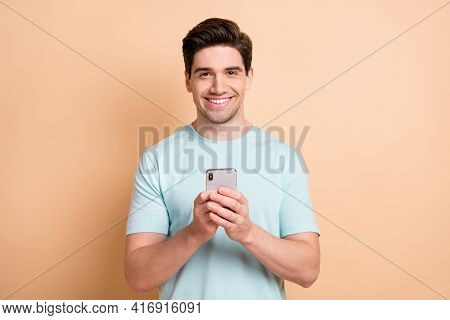 Portrait Of Nice Cheerful Guy Influenzer Blogger Using Gadget App 5g Post Media Isolated Over Beige 