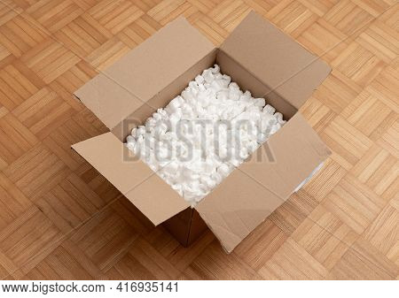 A Cardboard Box With Packing Styro Foam Pellets Top View