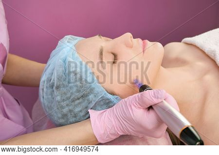 Needle Mesotherapy. Cosmetologist Performs Needle Mesotherapy On A Womans Face. Beautiful Woman Rece