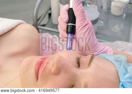 Needle Mesotherapy. Cosmetologist Performs Needle Mesotherapy On A Womans Face. Beautiful Woman Rece
