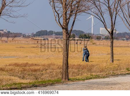 Pyeongtaek, South Korea; April 6, 2021: Unidentified Couple Playing Golf In Field Of Brown Dry Grass