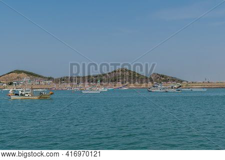 Pyeongtaek, South Korea; April 6, 2021: Fishing Trawlers Sailing Across Harbor With Private Yachts A