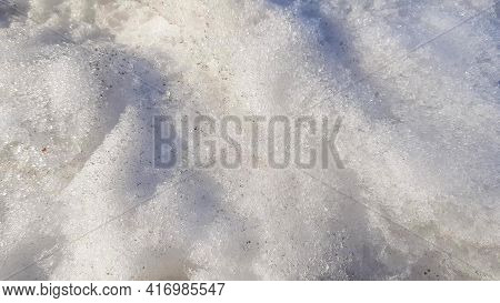 Close-up Of Dirty Snow With Frozen Ice In Early Spring. Sunlight And Shadows On Snow Texture, The Co