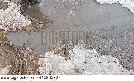 The Texture Of A Muddy Puddle With Snow, Ice And Debris, Spring Snowmelt, Outdoor Stream