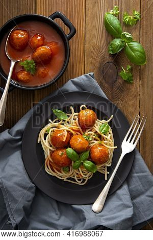 Spaghetti With Eatballs Tomato Sauce , Basil Leaves In Black Mate Plate On Wooden Background, Delici