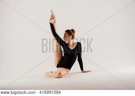 Portarit Of Sensual Professional Caucasian Callet Dancer In Body Suit And Pointes Shoes On White.