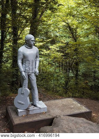 Russia, Sochi 12.07.2020. A Gray Monument To Vladimir Vysotsky With A Guitar Stands In A National Pa