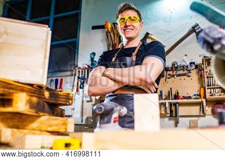 Carpenter Young Working With Wood In Workshop