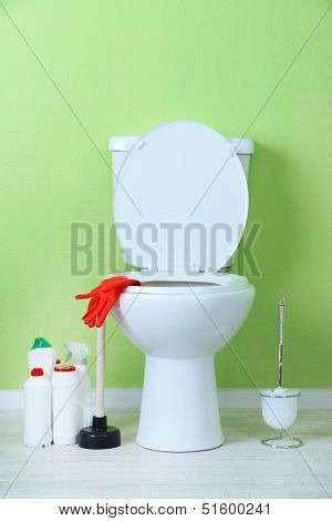 White toilet bowl and cleaner bottle in a bathroom