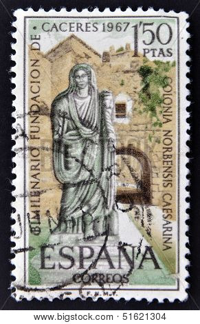 A stamp shows a picture of a Roman matron and the Arc of Christ in Caceres