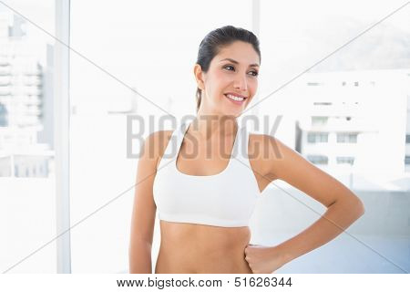 Fit happy woman in sportswear  at home in bright room