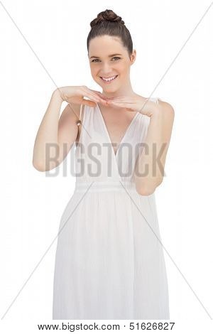 Smiling young model in white dress posing on white background