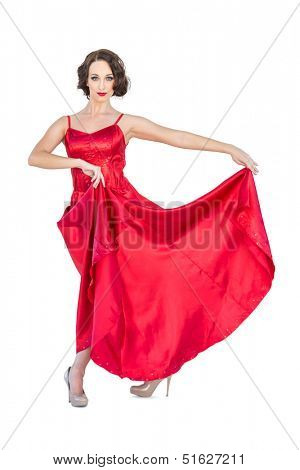 Gorgeous flamenco dancer posing on white background holding her dress