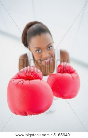 High angle view of happy fit woman with red boxing gloves in bright fitness studio