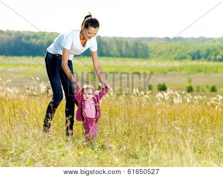 Happy young beautiful mather with smiling baby on nature