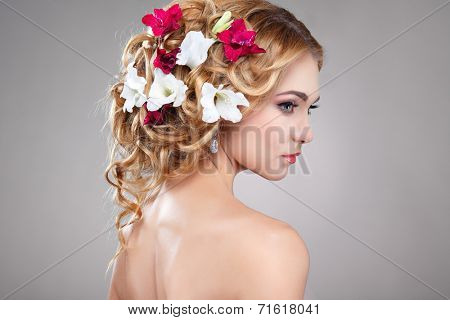 Beautiful girl, isolated on a light - grey background with varicoloured flowers in hairs, emotions, cosmetics