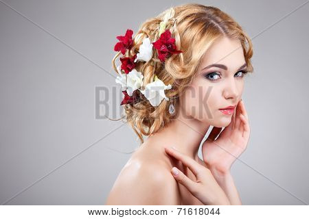 Beautiful girl, isolated on a light - grey background with varicoloured flowers in hairs, emotions, cosmetics