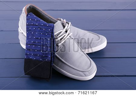 Top-Siders and pair of socks on dark blue wooden background