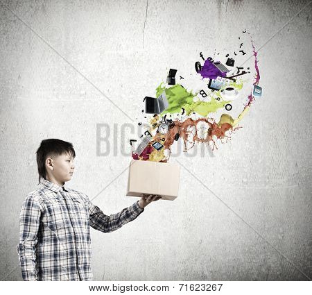 Young boy splashing colorful paint from carton box