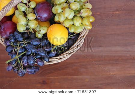 Fresh Fruit In The Basket On The Wooden Table