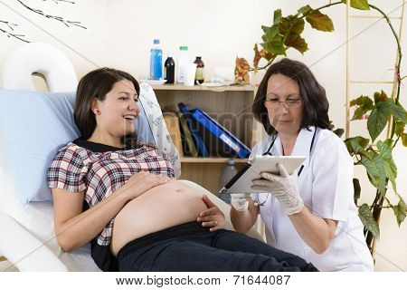 Pregnant Woman Checking Results On Tablet Computer