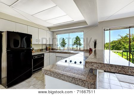 White Kitchen Room With Black Appliances And Granite Tops