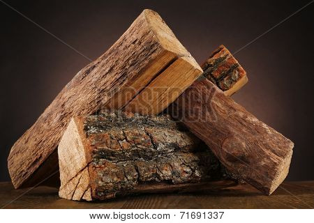 Heap of firewood on floor on dark background