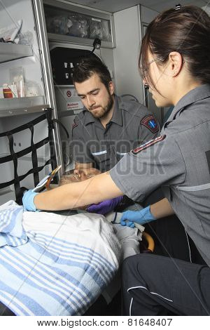 professional paramedics giving unconscious young woman first aid