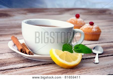 A cup of tea,muffin and lemon