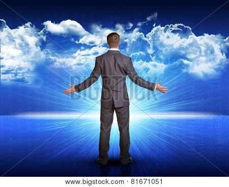 Businessman standing against blue landscape with rising sun