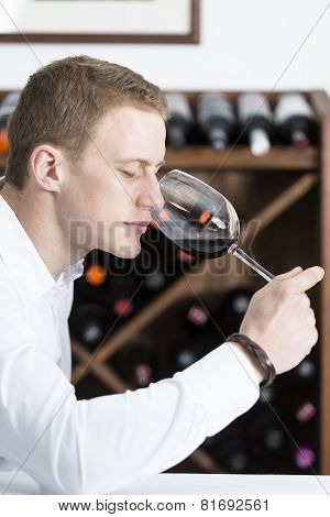 Man Smelling A Glass Of Red Wine.