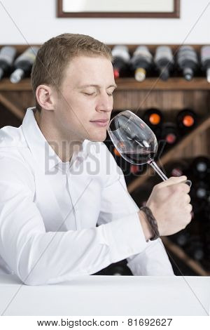 Man Smelling A Red Wineglass.