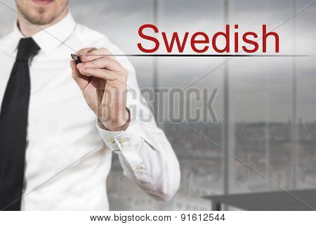 Businessman In Office Writing Swedish In The Air