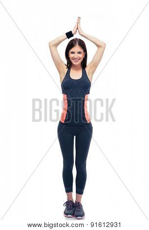 Full length portrait of a happy fitness woman doing yoga excersise isolated on a white background. Looking at camera