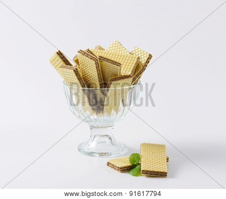chocolate wafers in glass rummer on white background