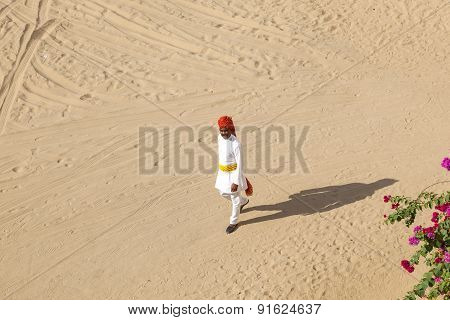 Rajasthani Man With Bright Red Turban And Bushy Mustache Walks Over The Sandy Area In The Desert Hot
