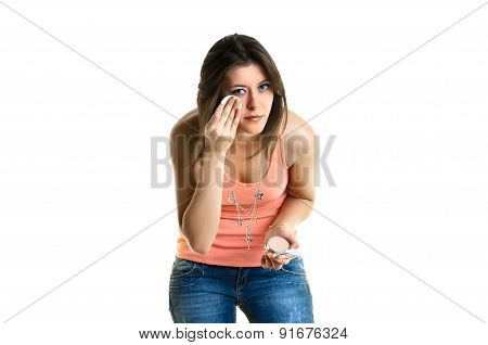 Beautiful young woman putting on make-up
