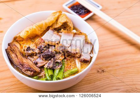 Delicious spicy curry noodle with roast pork cockles vegetable. Popular delicacy in Malaysia and Singapore