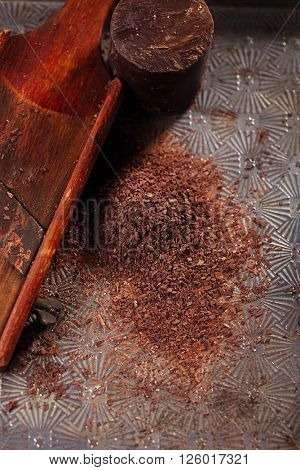 grated 100% dark chocolate flakes on vintage  wooden grate,   shallow DOF