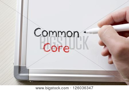 Human hand writing common core on whiteboard