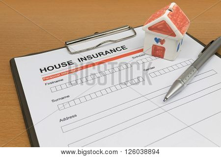 House Insurance application form with model house and pen