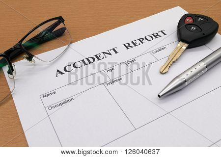 Accident report form with pen with glasses and key