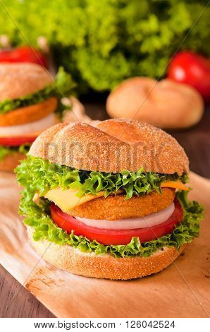 Fresh fishburger sandwich on the table. Selective focus in the middle of fishburger