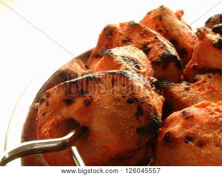 Indian Chicken Tikka Kebab Flame Grilled on rustic background